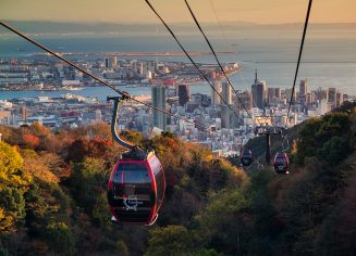 Kobe, Japan - November 25, 2016: Shin-Kobe Ropeway cable cars to Nunobiki Herb Garden with autumn foliage color and skyline city view at sunset.